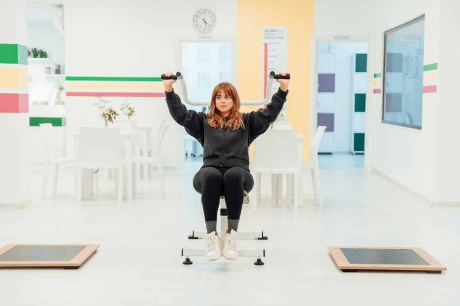 a woman is sitting on a chair with her hands in the air